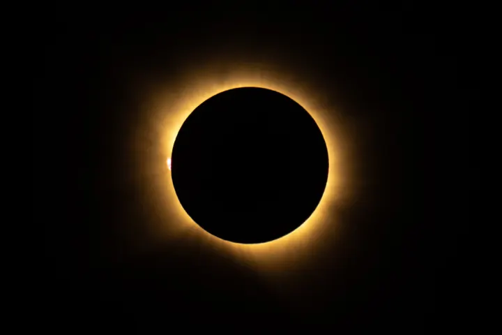 The Sun's white corona surrounding the black disc of the Moon during a total solar eclipse